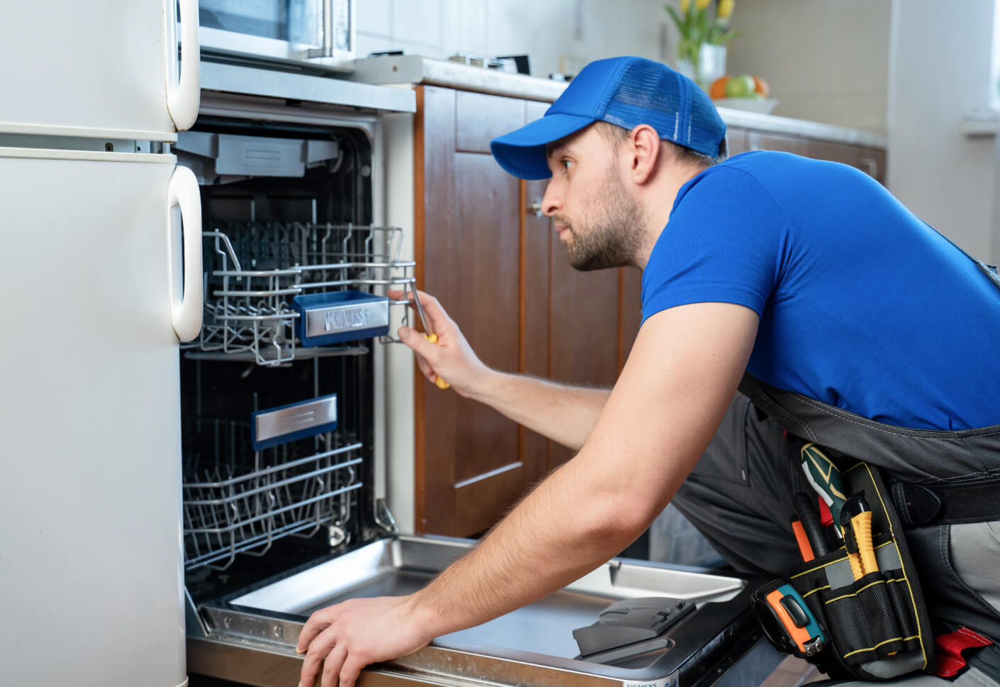 GRIT Appliance Repair Technician working on a dishwasher
